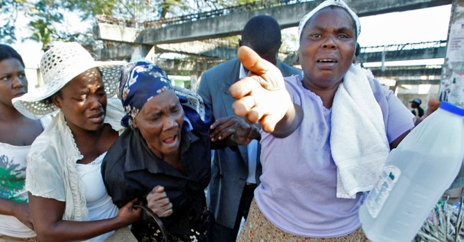 A group of women react Thursday as the daughter of the woman, at center, is still missing after the earthquake in Port-au-Prince.