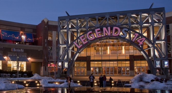 The Legends 14 movie theater sign is reflected in the fountain pool that is a centerpiece fixture in the shopping complex in Kansas City, Kan. Sales tax numbers show that the Legends and other shopping areas might be drawing people away from spending in Lawrence.