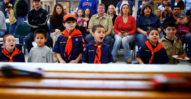 Members of Cub Scout Pack 3071 watch as race cars fly down the track during the pack’s annual Pinewood Derby on Saturday at Prarie Park School. Each car was required to weigh below five ounces.