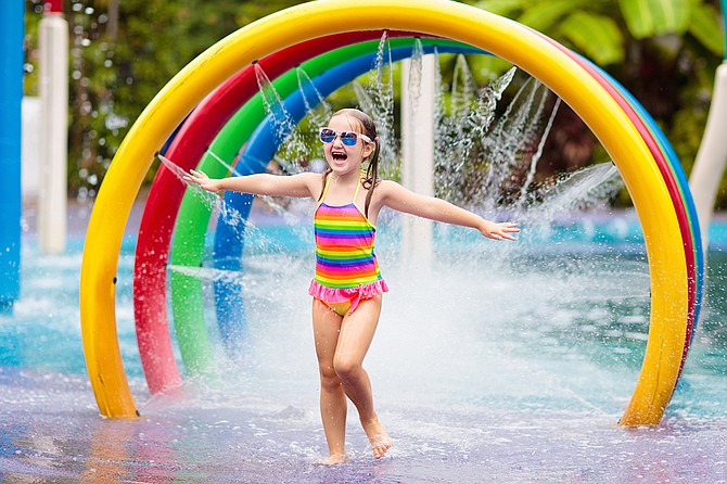 Kids play in aqua park. Children at water playground of tropical amusement park. Little girl at swimming pool. Child playing at water slide on summer vacation in Asia. Swim wear for young kid.